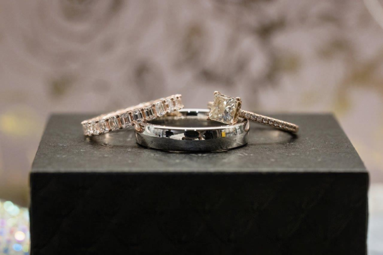 A diamond wedding band and diamond engagement ring sit atop a platinum wedding band.