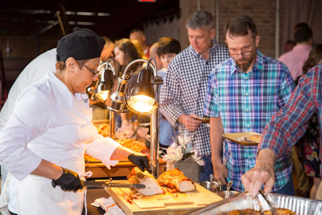 Guests help themselves to a buffet, with multiple carving stations.