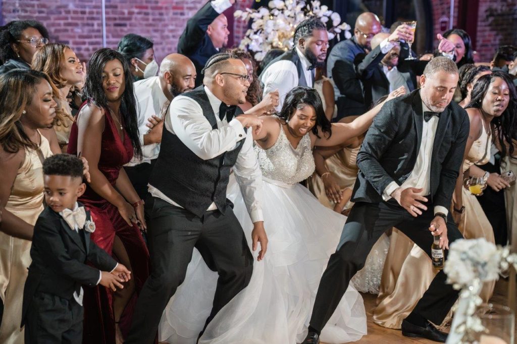 A bride & groom dance with their family and friends at their wedding reception, at Power House at Rocky Mount Mills.